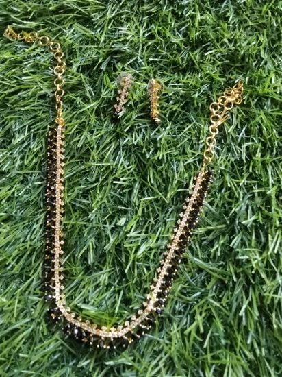 సాంప్రదాయ నల్ల పూసల నెక్లెస్ సెట్, మంగళసూత్ర-శైలి నెక్లెస్‌తో పాటు సరిపోయే చెవిపోగులు. యొక్క చిత్రం